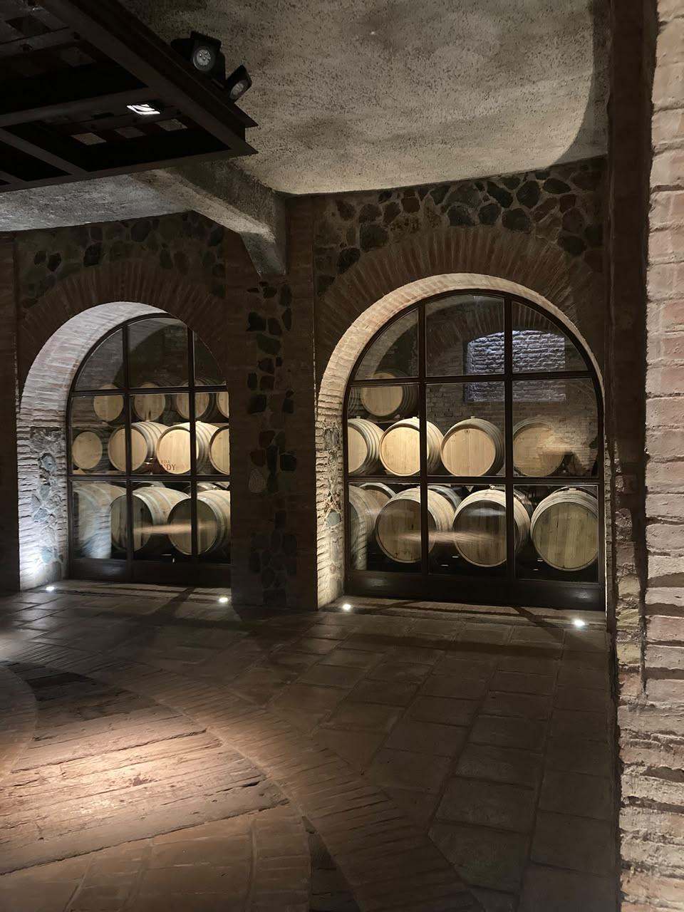 Brick archways framing rows of oak barrels